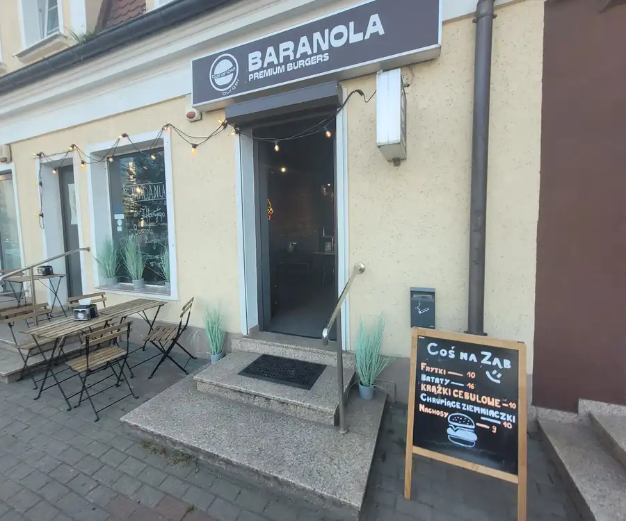 Wejście do Baranoli z szyldem nad drzwiami i stolikami przed lokalem
